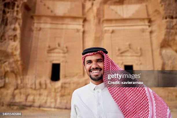 candid portrait of young saudi man visiting hegra - mada'in saleh stockfoto's en -beelden