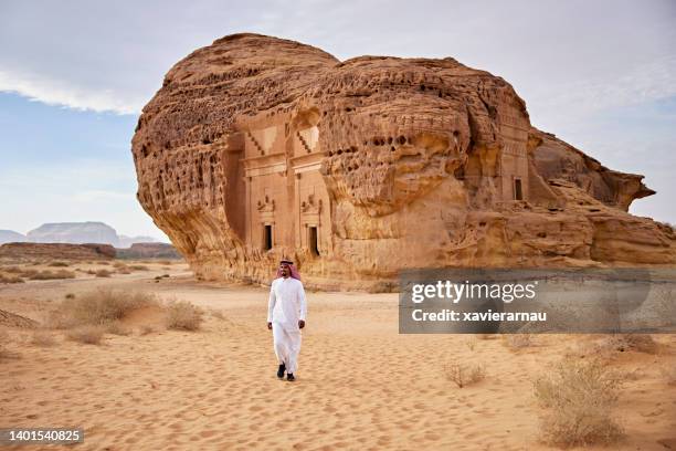 local saudi man visiting rock-cut architecture at hegra - middle eastern culture stock pictures, royalty-free photos & images