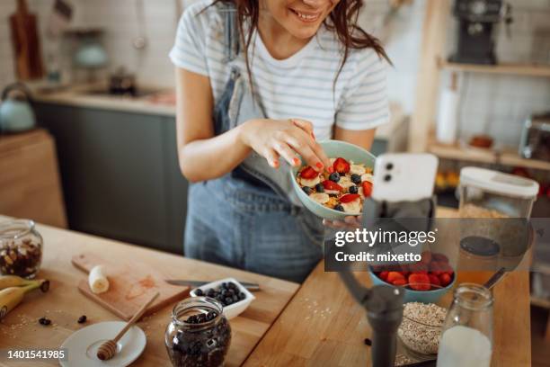giovane bella vlogger di cibo vegetariano al lavoro - social media influencers foto e immagini stock