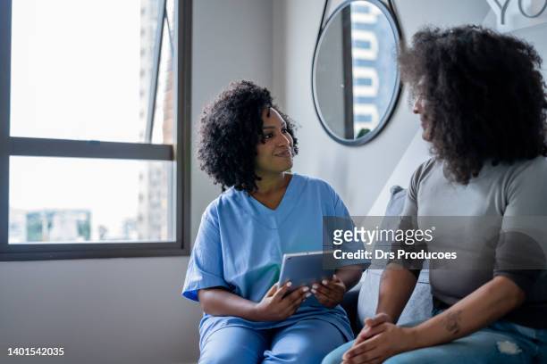 black nurse consulting trans woman at home - black transgender 個照片及圖片檔