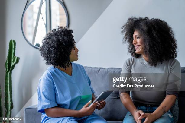 black nurse consulting trans woman at home - transgender bildbanksfoton och bilder