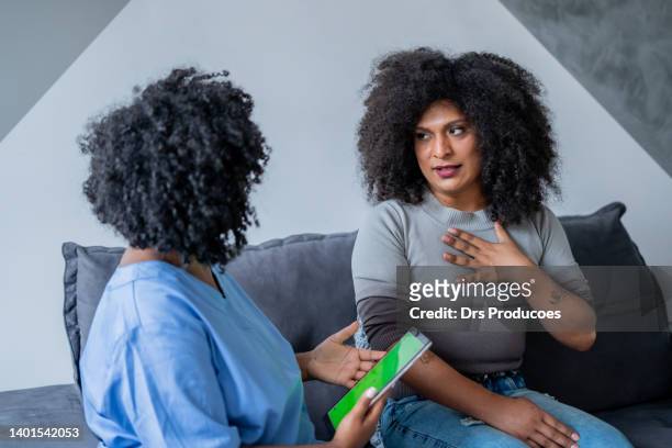 black nurse consulting trans woman at home - black transgender 個照片及圖片檔