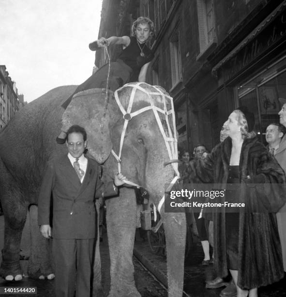 Le baptême d'un éléphant au champagne pour la pièce 'Azouk' par Marianne Cevenne, André Puglia et Dolly Fairlie, le 4 décembre 1953, au Théâtre...