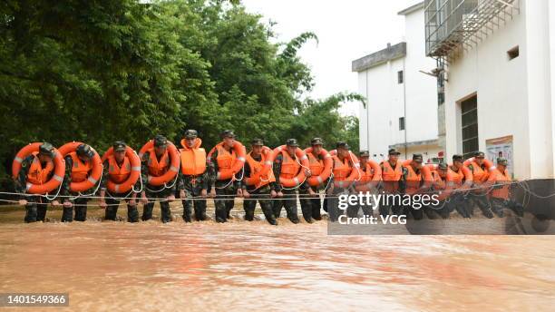 Armed police officers evacuate residents from a flood-hit area after torrential rains on June 6, 2022 in Ganzhou, Jiangxi Province of China.