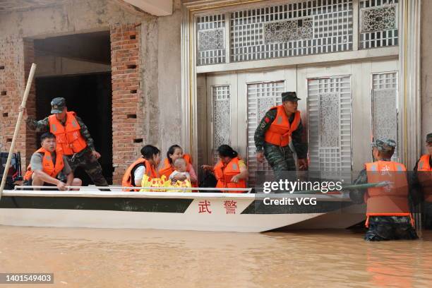 Armed police officers evacuate residents from a flood-hit area after torrential rains on June 6, 2022 in Ganzhou, Jiangxi Province of China.