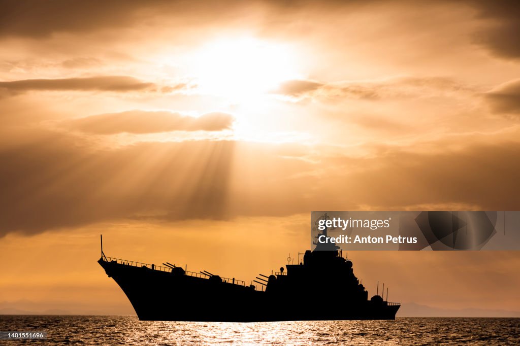 Warship at sunset in the sea. Fleet flagship