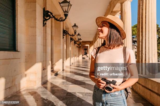 junge touristin, die die griechische architektur genießt - corfu town stock-fotos und bilder