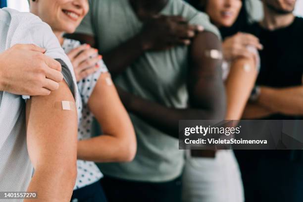 friends showing their arms after getting vaccinated. - arm pointing stock pictures, royalty-free photos & images