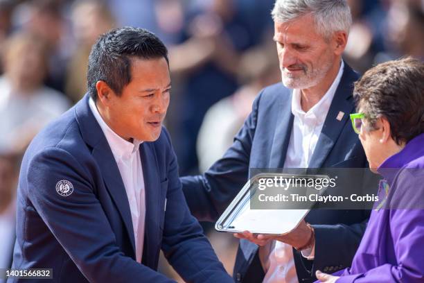 Umpire James Keothavong receives a trophy from Billie Jean King watched by French Tennis Federation President Gilles Moretton after umpiring the...