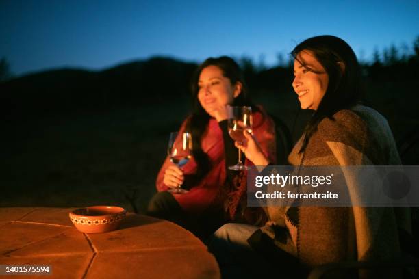 female friends by fire pit - backyard firepit stock pictures, royalty-free photos & images