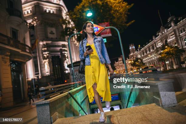 woman with mobile phone leaving the subway - metro madrid stock pictures, royalty-free photos & images