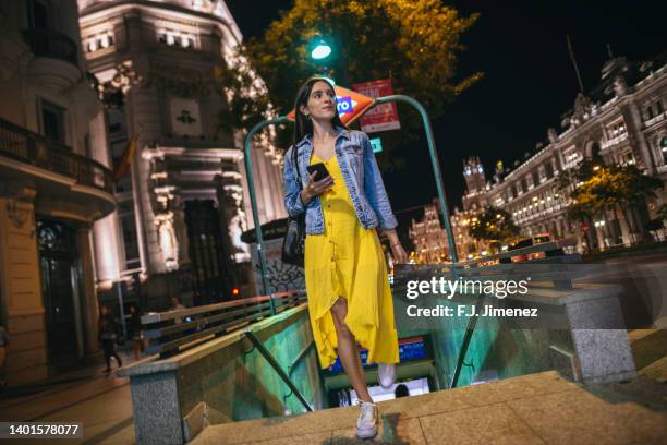 woman with mobile phone leaving the subway - street light imagens e fotografias de stock