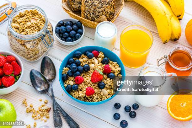 healthy well balanced breakfast on white table - granola stock pictures, royalty-free photos & images