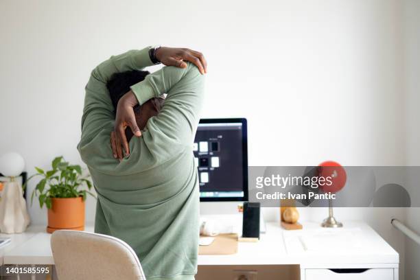 freelancer que tiene problemas con su espalda en casa - bad posture fotografías e imágenes de stock