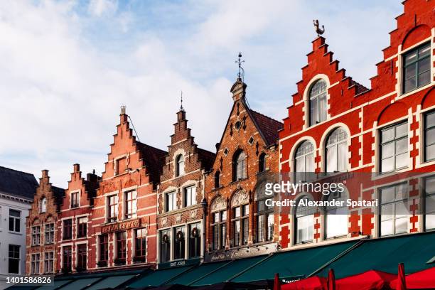traditional medieval belgian houses at market square in bruges, belgium - traditionally belgian stock pictures, royalty-free photos & images