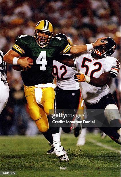 Quarterback Brett Favre of the Green Bay gives a stiff arm to linebacker Bryan Cox of the Bears during the Packers 38-24 win over the Chicago Bears...
