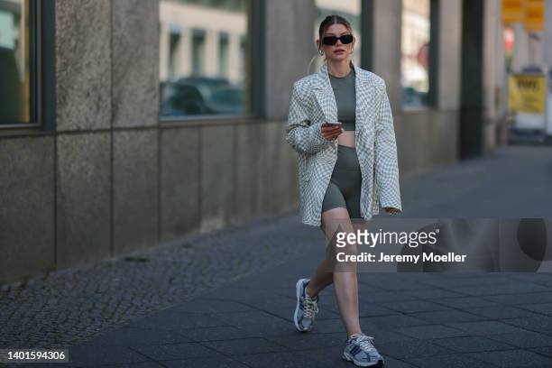 Sophia Geiss seen wearing a black sunglasses from Prada, white/light green checkered oversize blazer from NA-KD, a dark green sport set from Adanola...