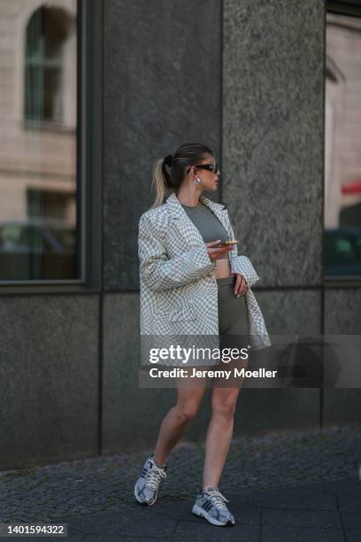 Sophia Geiss seen wearing a black sunglasses from Prada, white/light green checkered oversize blazer from NA-KD, a dark green sport set from Adanola...