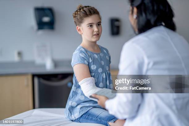 girl with a broken arm at the doctors - child having medical bones stock pictures, royalty-free photos & images