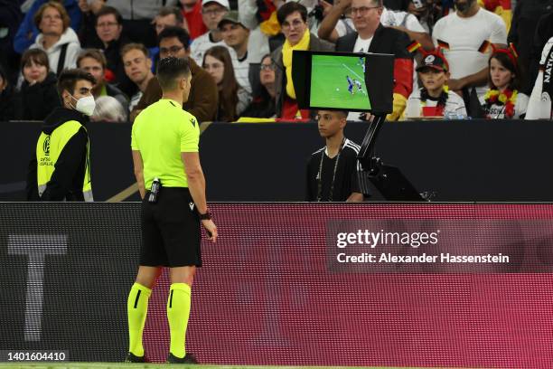 Referee Carlos del Cerro Grande checks the VAR screen for a possible penalty to England after a foul on Harry Kane, which is later given during the...