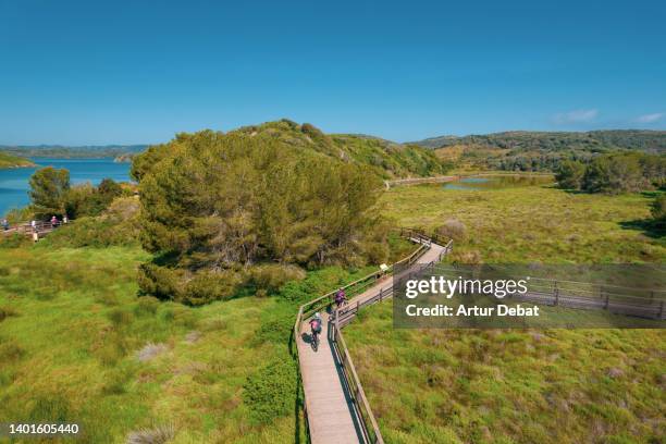 drone view doing a mountain bike route in the nature wetlands of menorca island. spain. - es grau menorca stock pictures, royalty-free photos & images