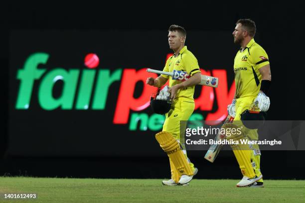 Australian batsmen Aaron Finch and David Warner leave the ground after winning the match during the 1st match in the T20 International series between...