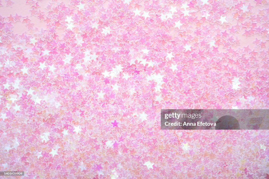 Background made of many small bright pink stars. Holiday concept. Flat lay style
