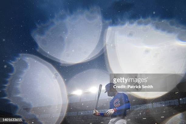 Jason Heyward of the Chicago Cubs stands on deck as rain falls before batting against the Baltimore Orioles at Oriole Park at Camden Yards on June...
