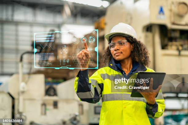 female engineer working on digital tablet and digitalization display in the production area. she had a development program for use in the automobile industry. production improvement concepts. - data processing stockfoto's en -beelden