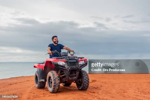 man contemplating the view on his atv - quadbike stock pictures, royalty-free photos & images