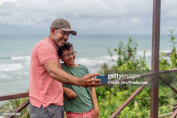 father and son taking selfie on the beach - iphone 11 stock pictures, royalty-free photos & images