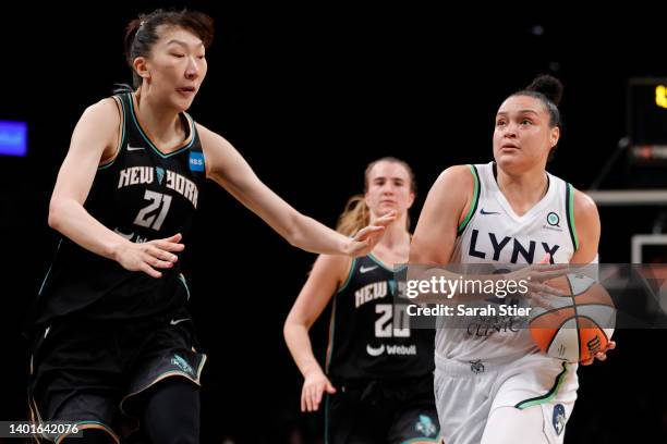 Guard Kayla McBride of the Minnesota Lynx dribbles as center Han Xu of the New York Liberty defends during the first half at Barclays Center on June...