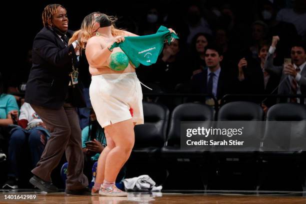 Protestors are taken off the court during the second half between the New York Liberty and the Minnesota Lynx at Barclays Center on June 07, 2022 in...