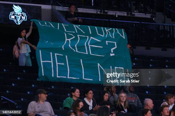 Protestors display signs during the second half between the New York Liberty and the Minnesota Lynx at Barclays Center on June 07, 2022 in the...