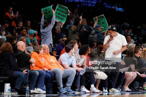 Protestors display signs during the second half between the New York Liberty and the Minnesota Lynx at Barclays Center on June 07, 2022 in the...