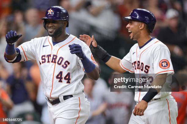 Yordan Alvarez of the Houston Astros celebrates with Michael Brantley after hitting a two run home during the eighth inning against the Seattle...