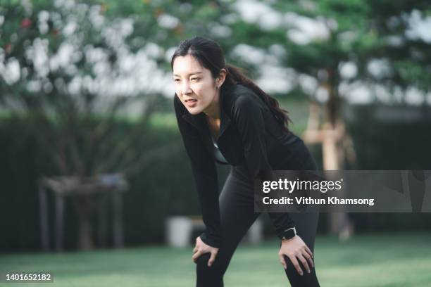 young asian women sports tired after exercise and runs at public park. - day of yoga in bangkok stock-fotos und bilder