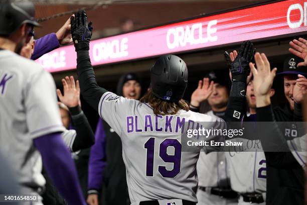 Charlie Blackmon of the Colorado Rockies is congratulated by teammates in the dugout after he hit a pinch-hit three-run home run int he sixth inning...