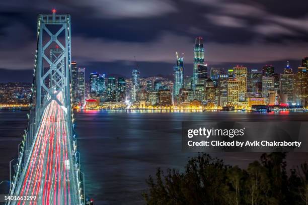 san francisco skyline and san francisco pier with bay bridge during evening - silicon valley stockfoto's en -beelden