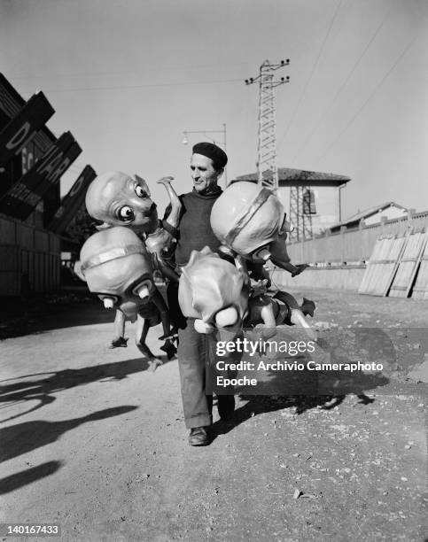 Alfredo Pardini, creator of the Notte de Carnevale float for the Carnival of Viareggio in Tuscany, Italy, with some of his creations, 1951.