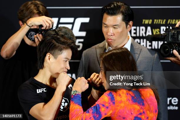 Zhang Weili of China and Joanna Jedrzejczyk of Poland face off ahead of their strawweight bout as UFC Senior Vice President Kevin Chang looks on...