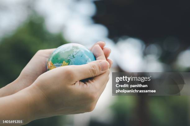 close up hand hold little world with green natural backgorund. concept for eco friendly and green life. - world children day stock pictures, royalty-free photos & images