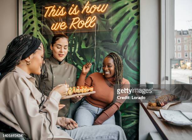 friends enjoying sharing vegan sushi in a local restaurant - japanese food stock pictures, royalty-free photos & images