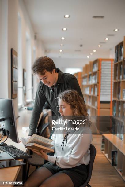 zwei universitätsstudenten arbeiten gemeinsam in einer öffentlichen bibliothek - two men studying library stock-fotos und bilder