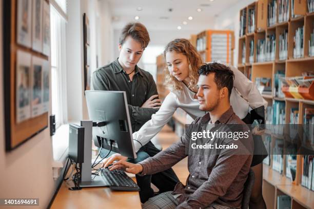 three university students working together in a public library - linguistics 個照片及圖片檔