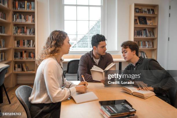 three university students working together in a public library - linguistics 個照片及圖片檔