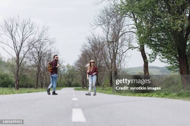 couple walking on the road - medium shot stock pictures, royalty-free photos & images