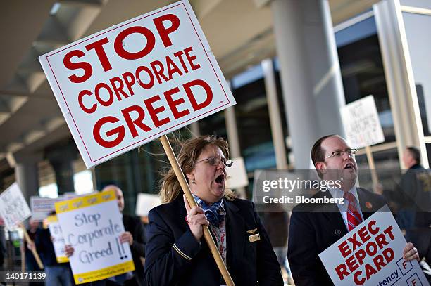 American Airlines employee Mary Oswald, an American Eagle flight attendant, center, demonstrates with others outside American Airlines Terminal 3 at...