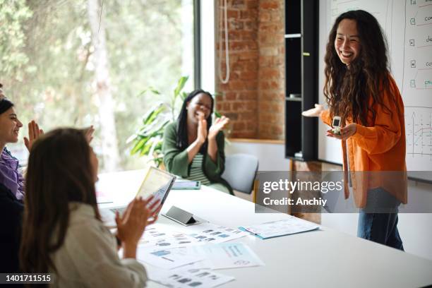 female entrepreneur giving presentation over whiteboard during meeting in office - sales pitch stock pictures, royalty-free photos & images