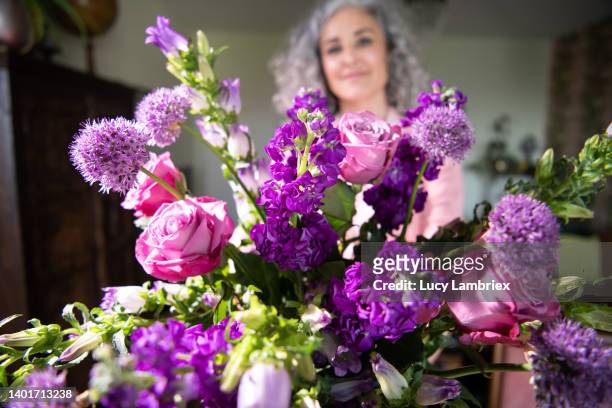 beautiful woman shows the purple bouquet she made - allium flower stockfoto's en -beelden